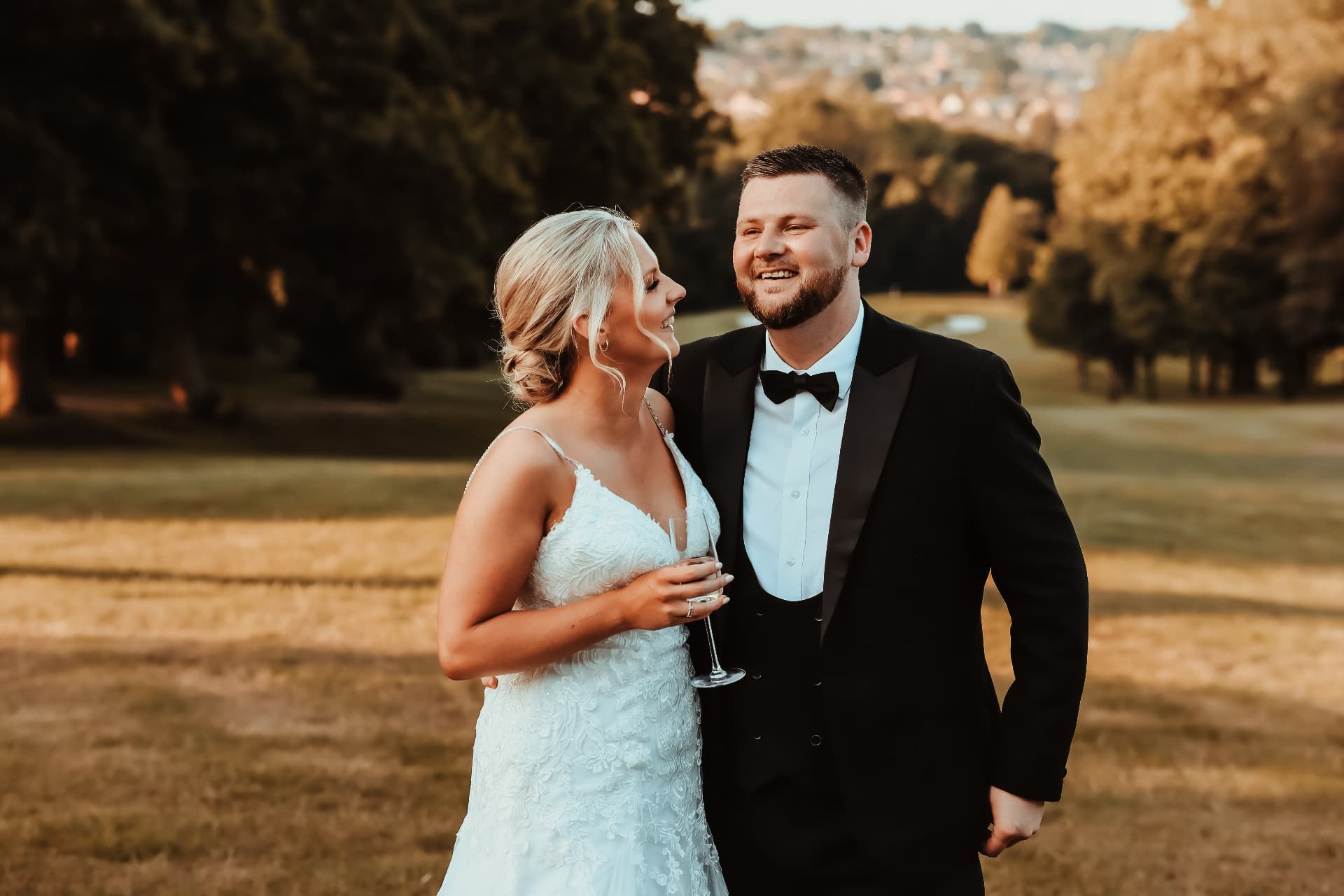 Bride and groom laughing together at golden hour